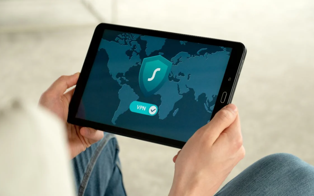 The image shows a tablet displaying a world map and VPN (Virtual Private Network) and security icons, suggesting the importance of online privacy and security.