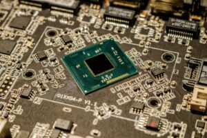 Detailed view of a green computer processor chip centered on a complex motherboard with numerous electronic components and connection points