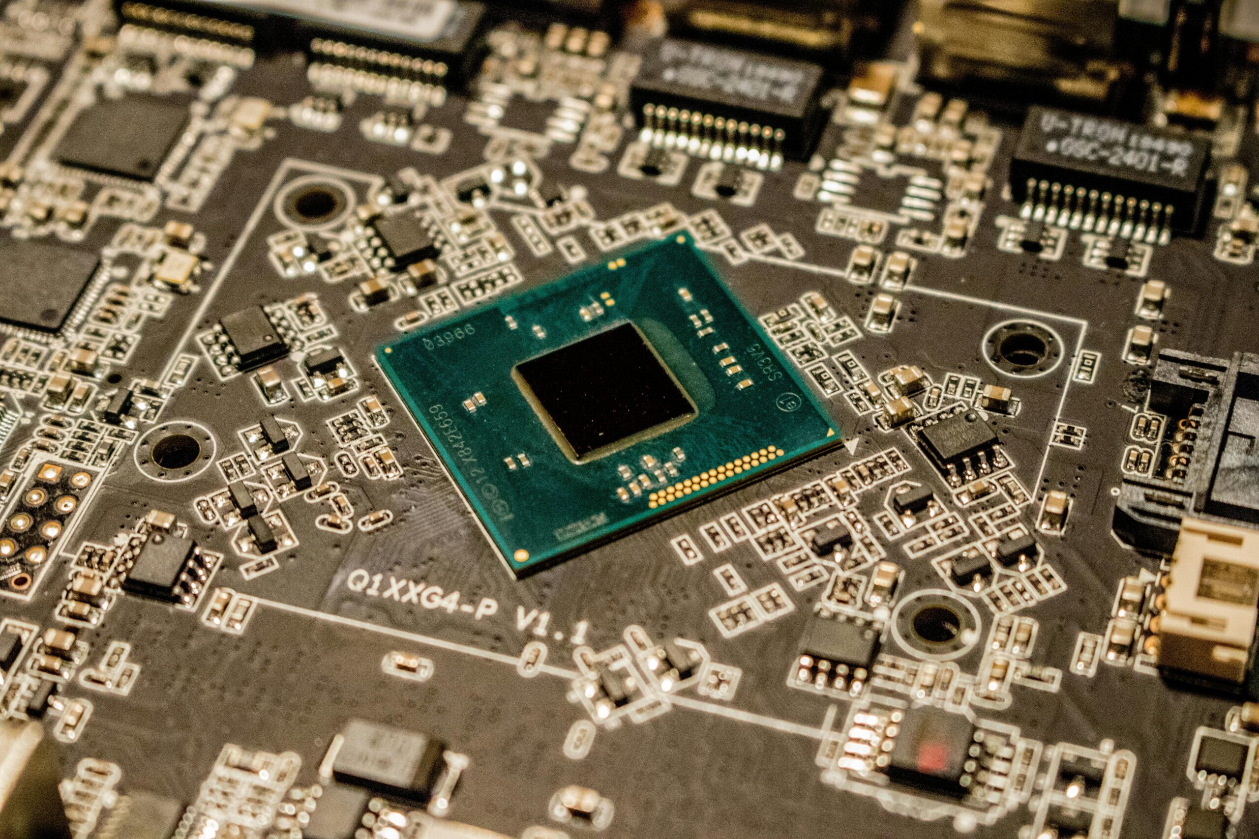 Detailed view of a green computer processor chip centered on a complex motherboard with numerous electronic components and connection points