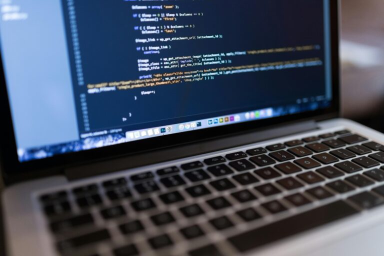 Computer monitor displaying a programming interface with various lines of code and a keyboard in the lower portion of the image.