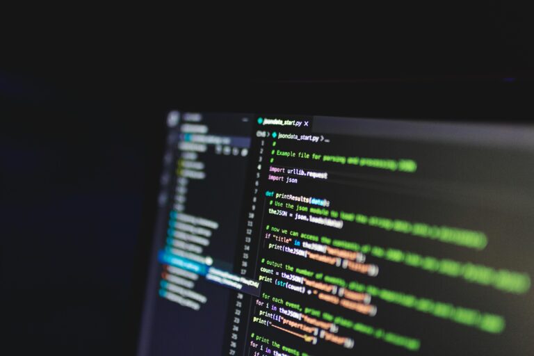 Laptop screen showing a code editor interface with lines of code, comments, and syntax coloring, representing a programming task or project.