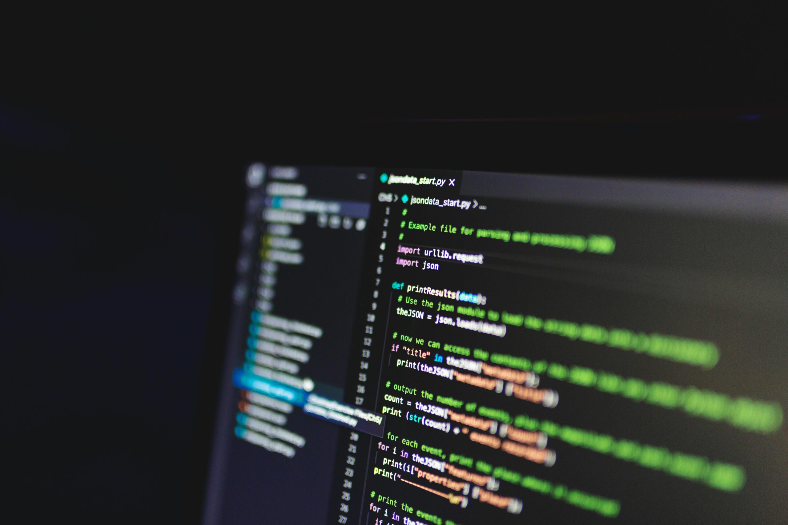 Laptop screen showing a code editor interface with lines of code, comments, and syntax coloring, representing a programming task or project.