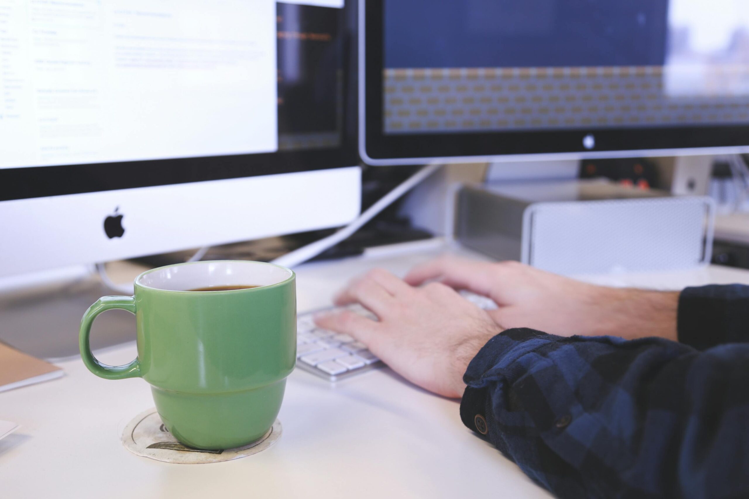 Technology and comfort: An image capturing the blend of digital tools and personal comforts, with a computer monitor, keyboard, and a warm mug creating a cozy work environment.
