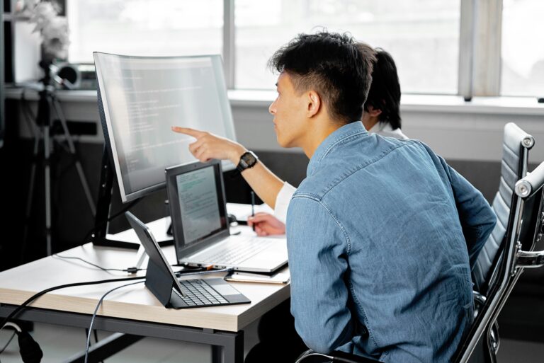 Developer or programmer deeply engaged with their computer setup in a contemporary office setting.