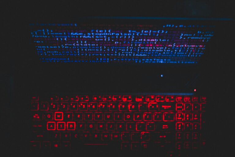Futuristic-looking keyboard with vibrant blue and red lighting, surrounded by a dark background.