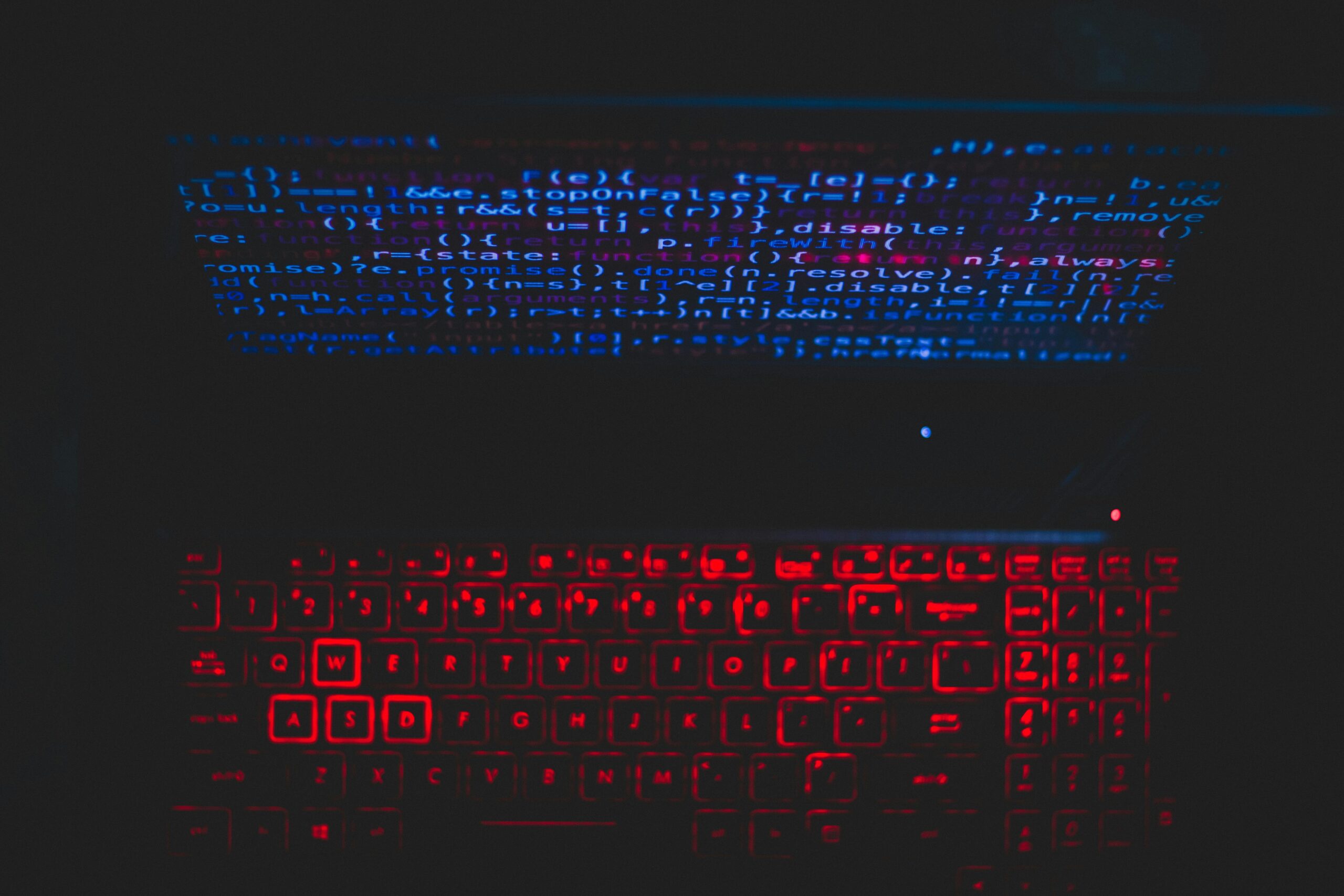 Futuristic-looking keyboard with vibrant blue and red lighting, surrounded by a dark background.