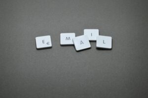 Minimalist image showing individual keyboard keys that spell out the word "Email" against a neutral gray backdrop.